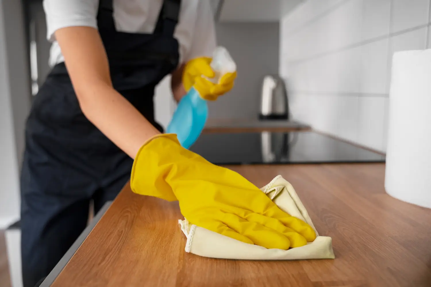 Detail of a cleaning technician wiping a counter